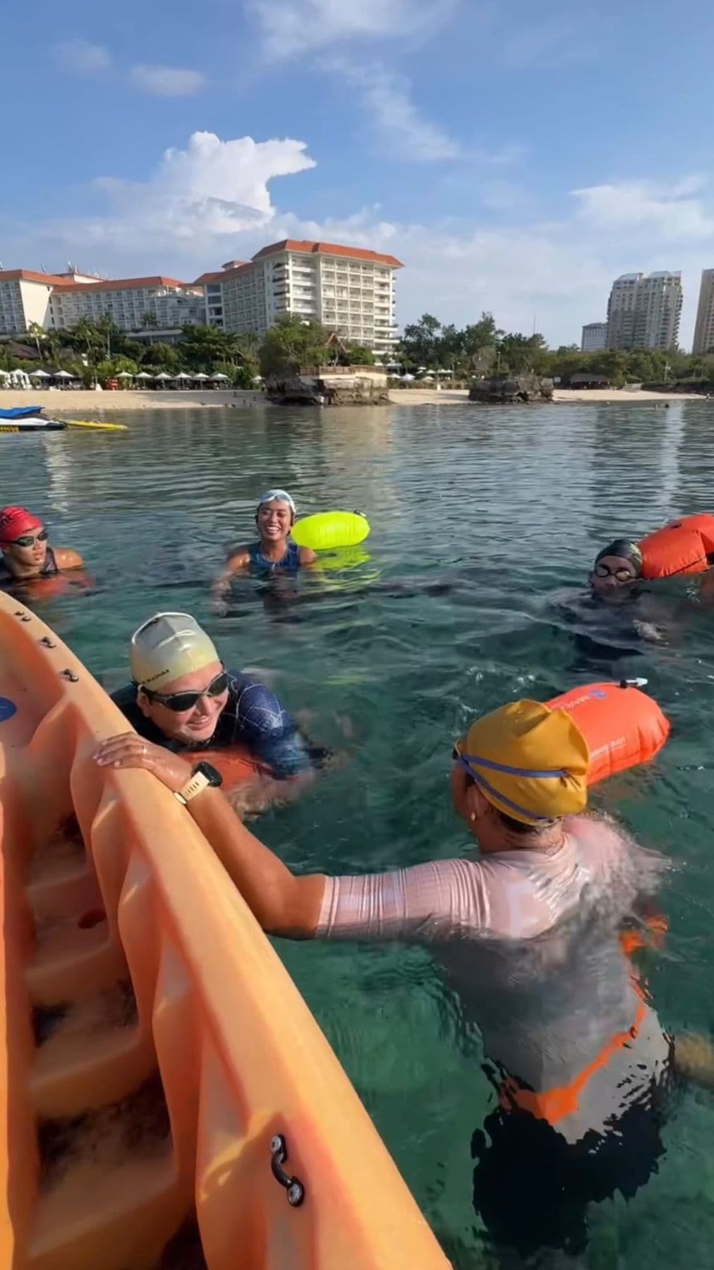Swimmers holding onto a kayak during an open-water session
