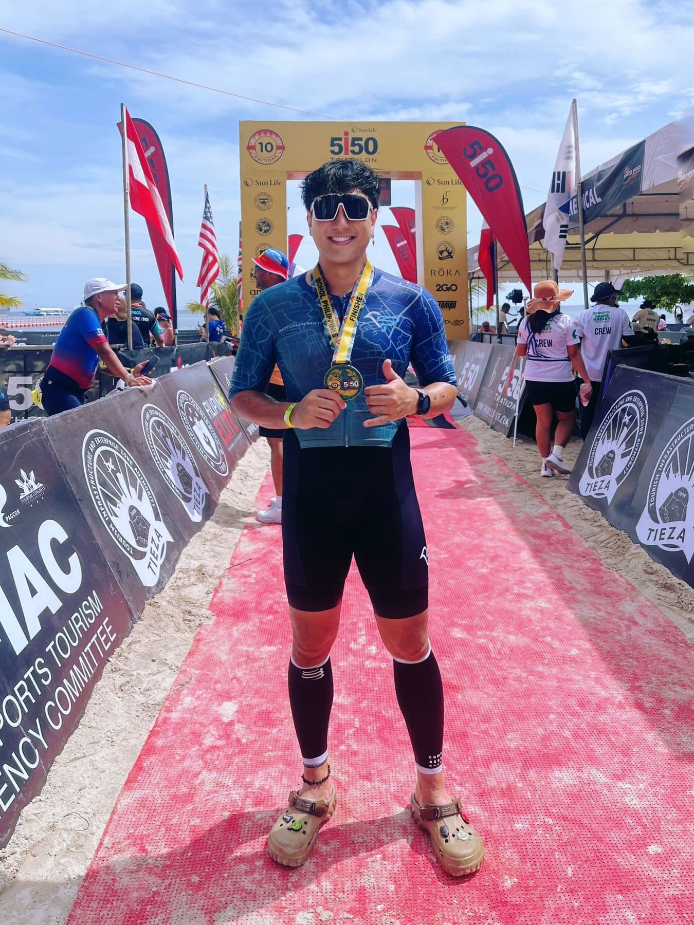 Triathlete showing a finisher's medal on the red carpet at a 5150 triathlon