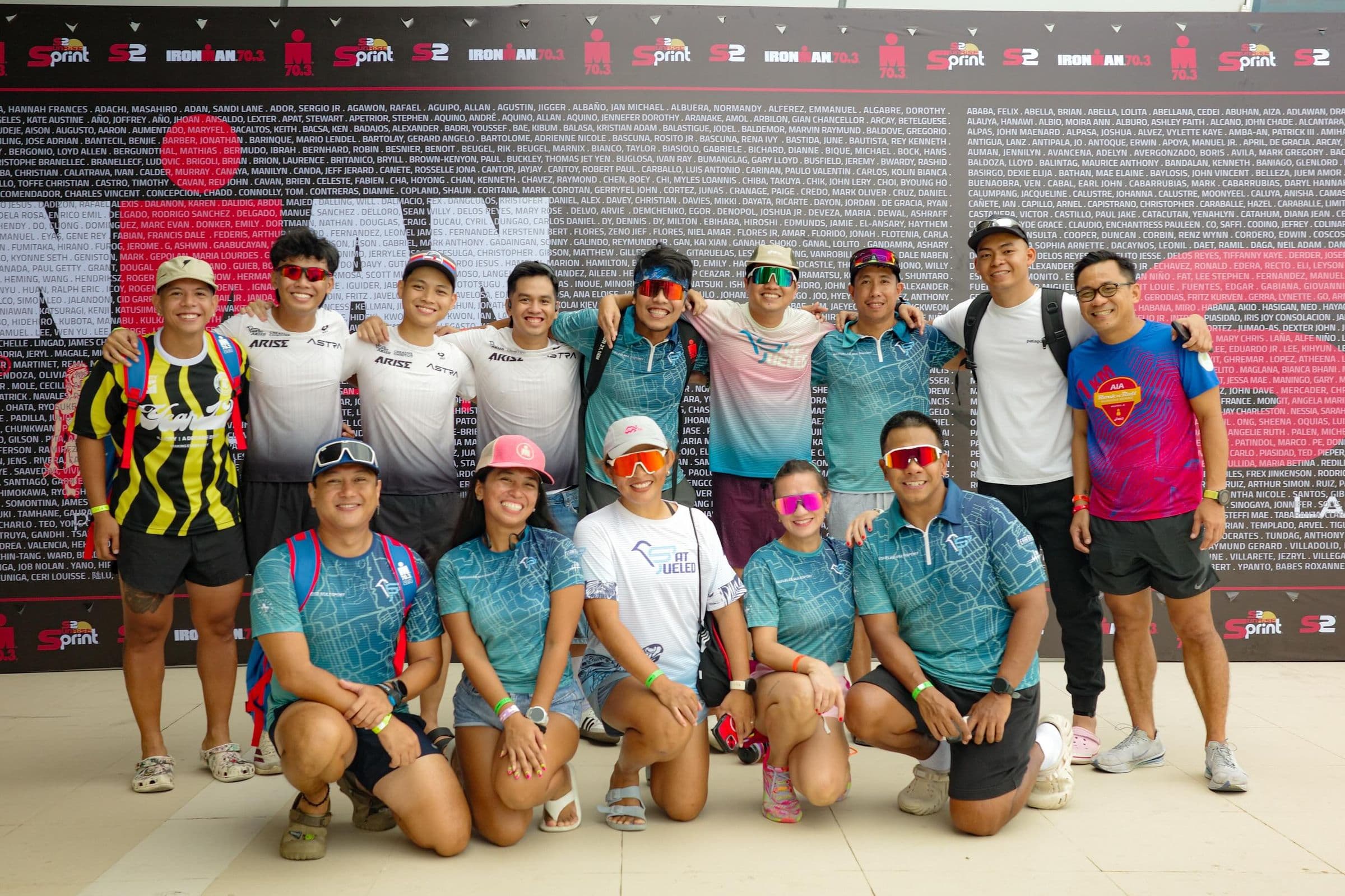 Fat Fueled athletes posing together in front of an IRONMAN wall