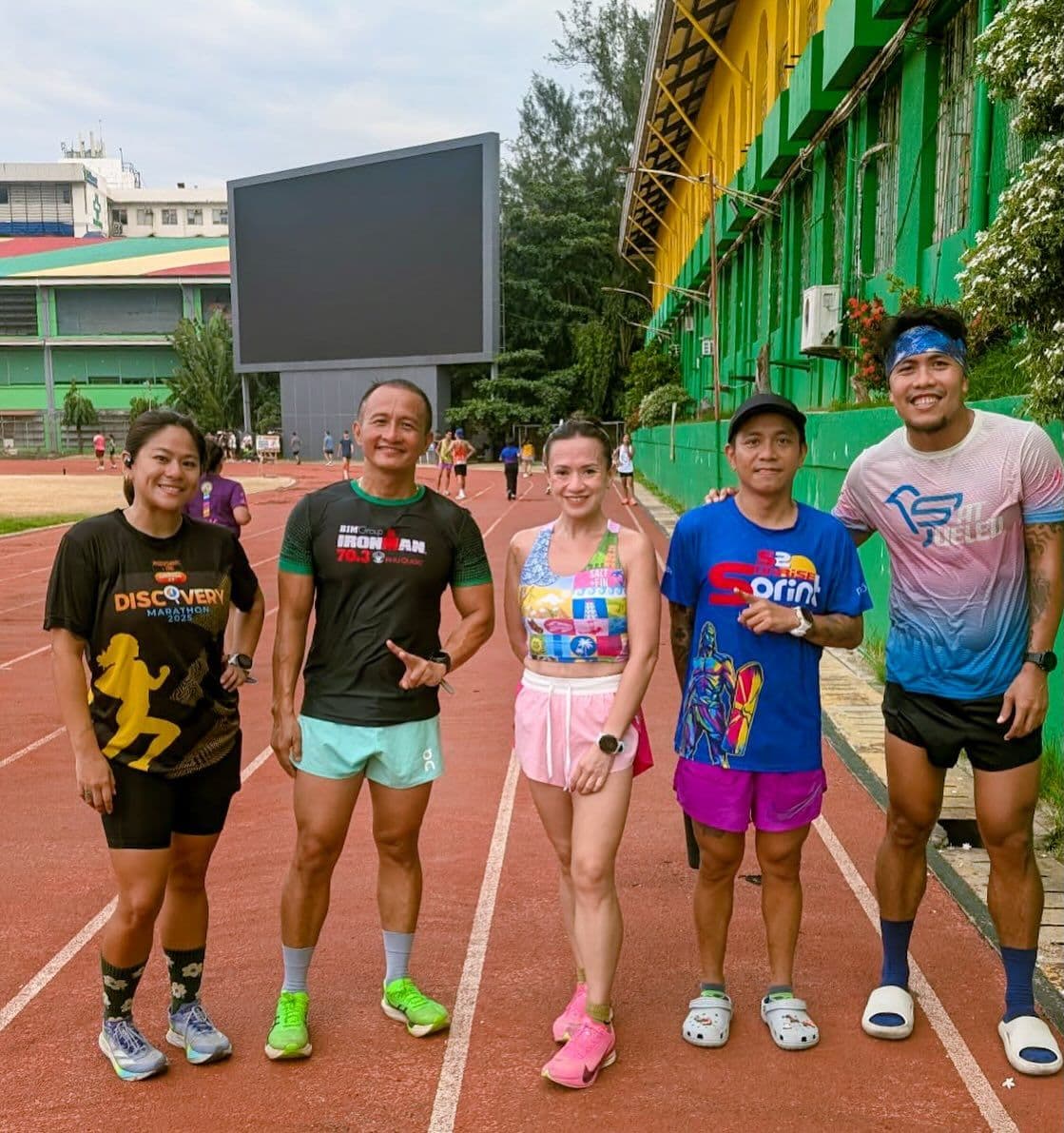 Runners in colorful kits posing on a running track