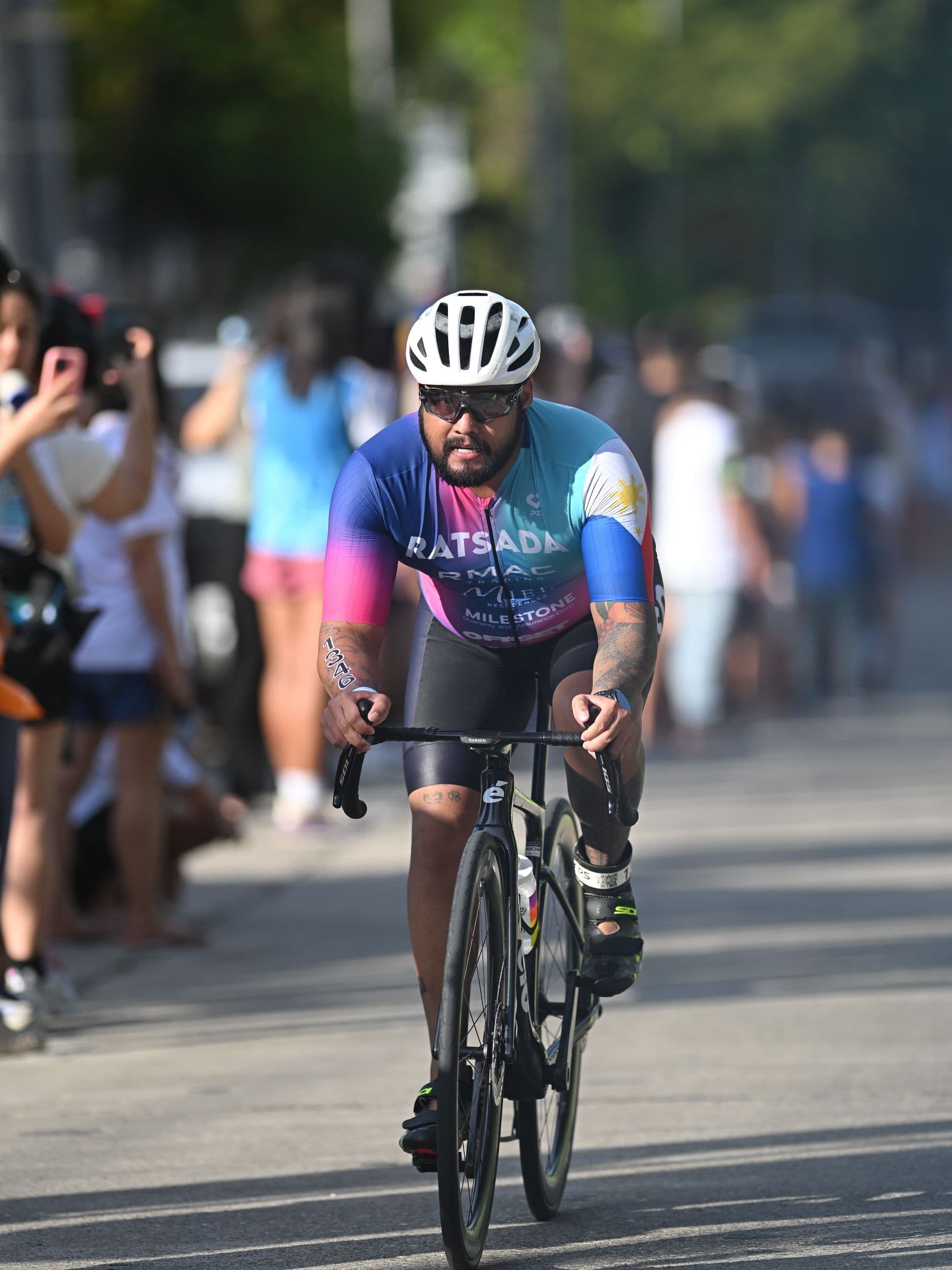 Cyclist in a helmet riding past a crowd of spectators during a race