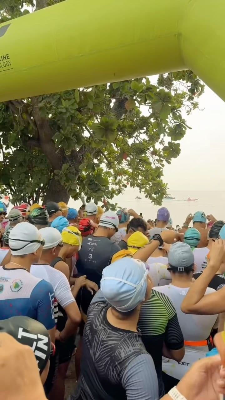 Swimmers in caps crowded together at a race start