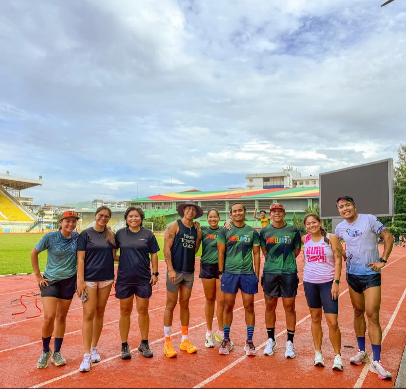 Athletes lined up together on a red running track